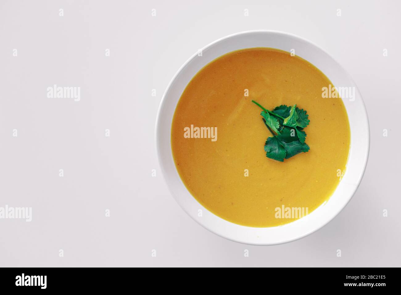 Hausgemachte Kürbissuppe mit Grüns auf weißem Hintergrund Stockfoto