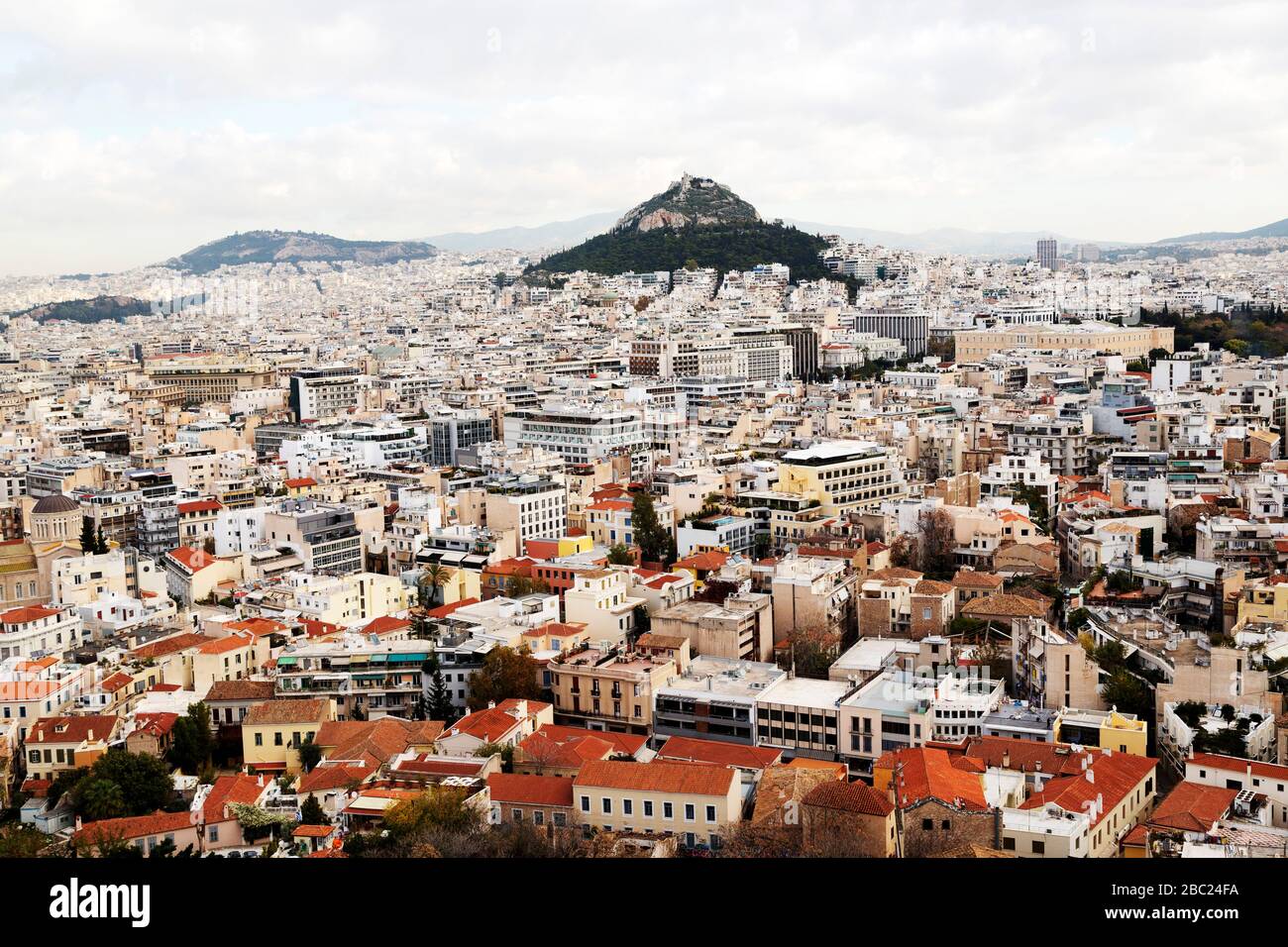Der Berg Lycabettus erhebt sich über den Gebäuden im Zentrum Athens, Griechenland. Die Kapelle des heiligen Georg führt den Hügel hoch. Stockfoto