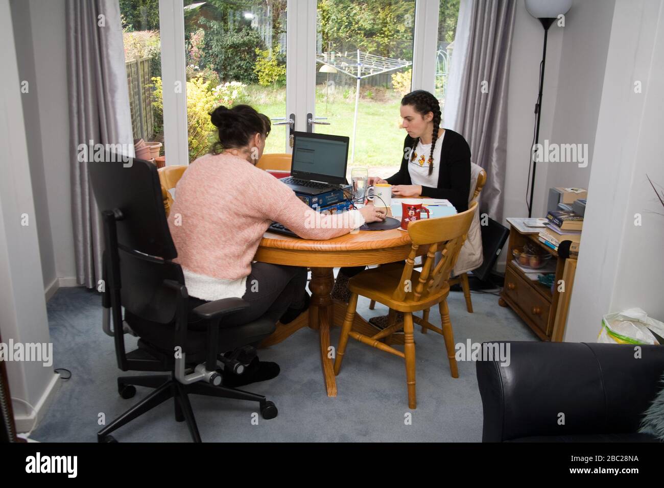 Büroangestellte sitzen am Tisch und arbeiten von zu Hause aus Stockfoto
