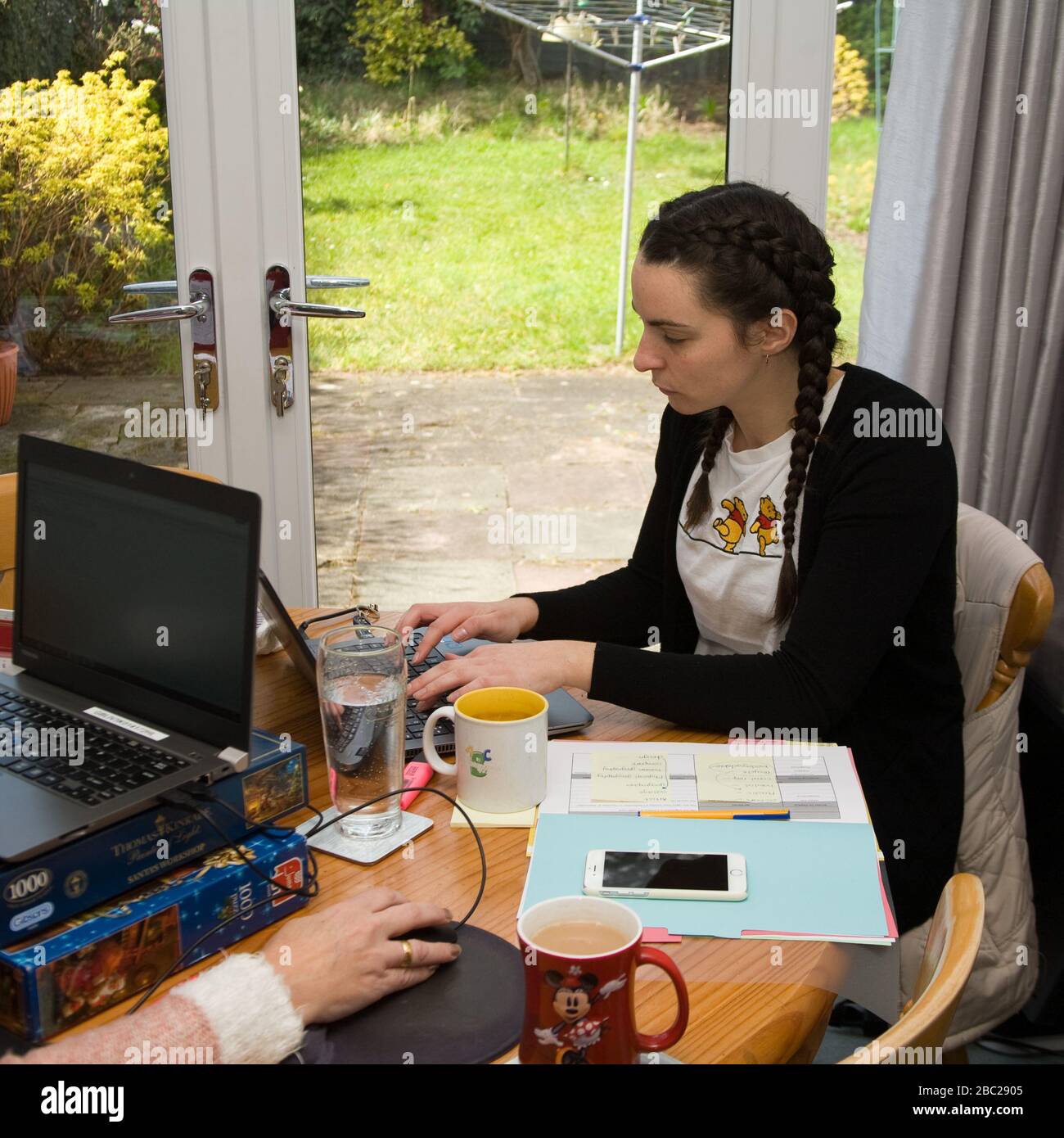 Büroangestellte sitzen am Tisch und arbeiten von zu Hause aus Stockfoto