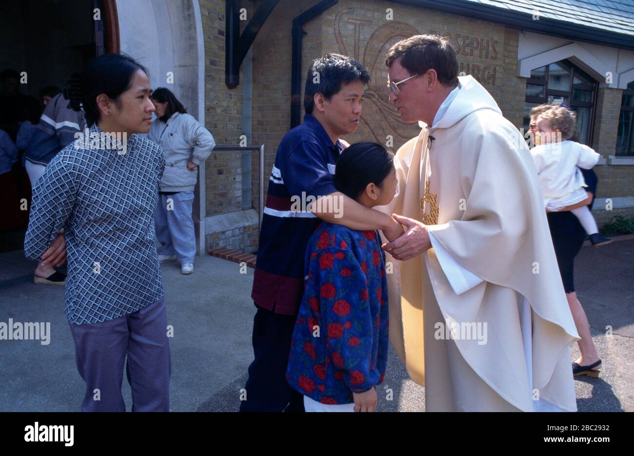 Priester der St. Joseph's Church Family Greeting nach der Messe Roehampton Stockfoto