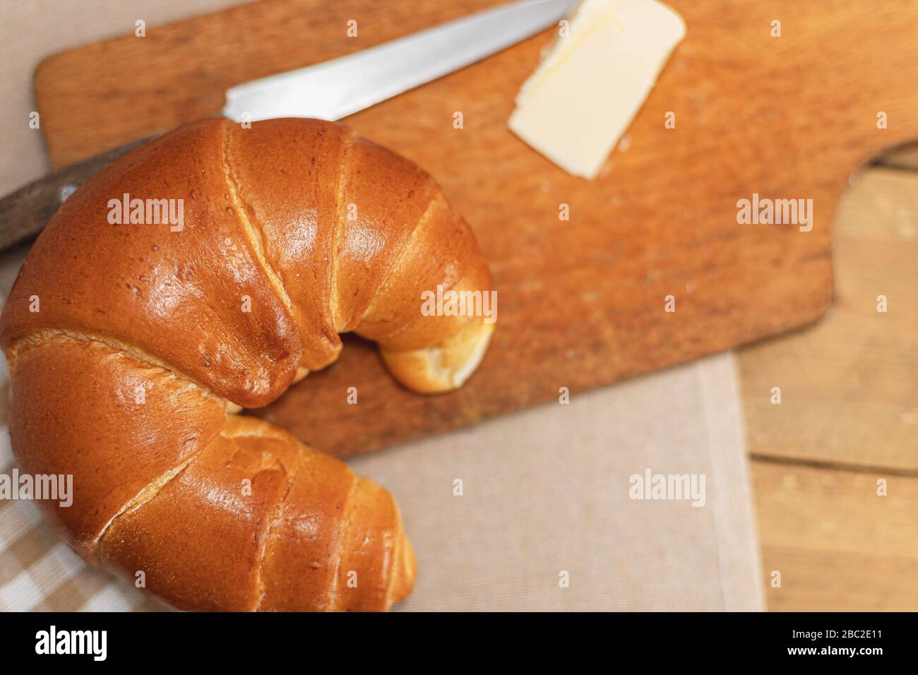 Croissant, Butter zum Frühstück. Frühstück auf einem rustikalen Tisch. Eine Mahlzeit auf dem Land. Backwaren. Polnisches Gebäck. Stockfoto