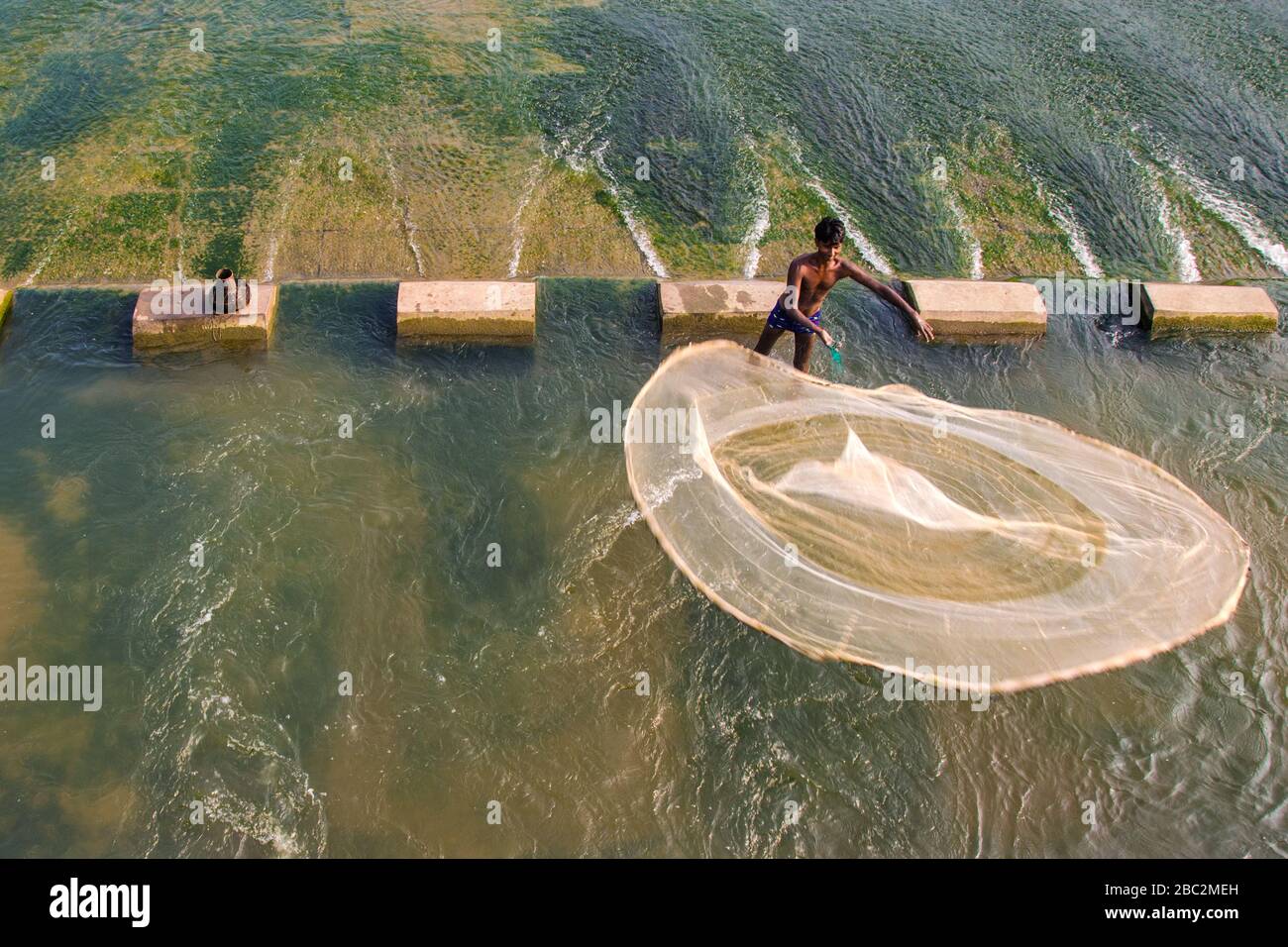 Fischer werfen ein Fischnetz zum Fangen von Fischkanteneinfangen Stockfoto