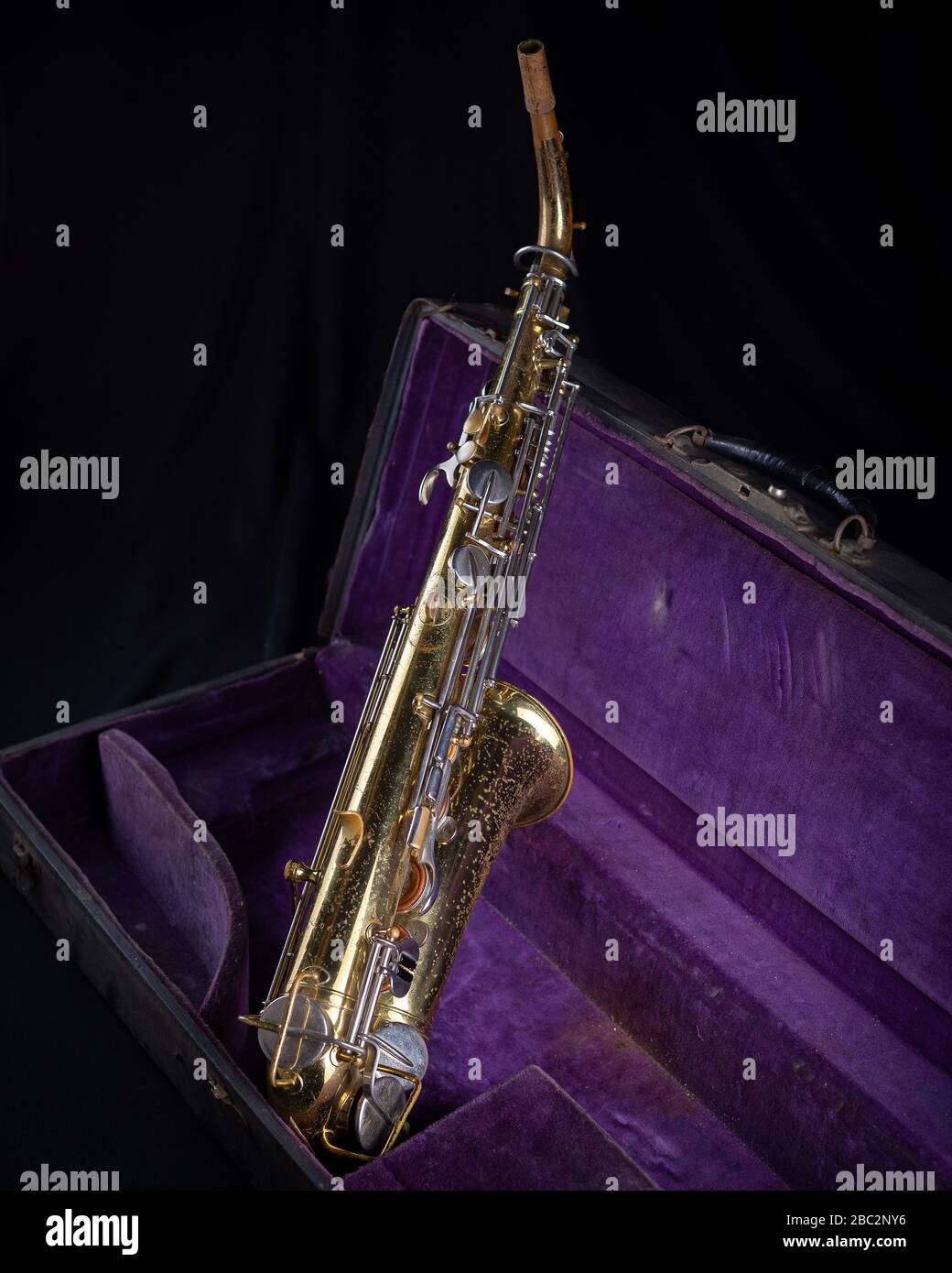 Buescher Alto Sax, Gold lackiert in Deep Purple Velvet-Lined Hartschalenkoffer Back 2 auf schwarzem Hintergrund Stockfoto