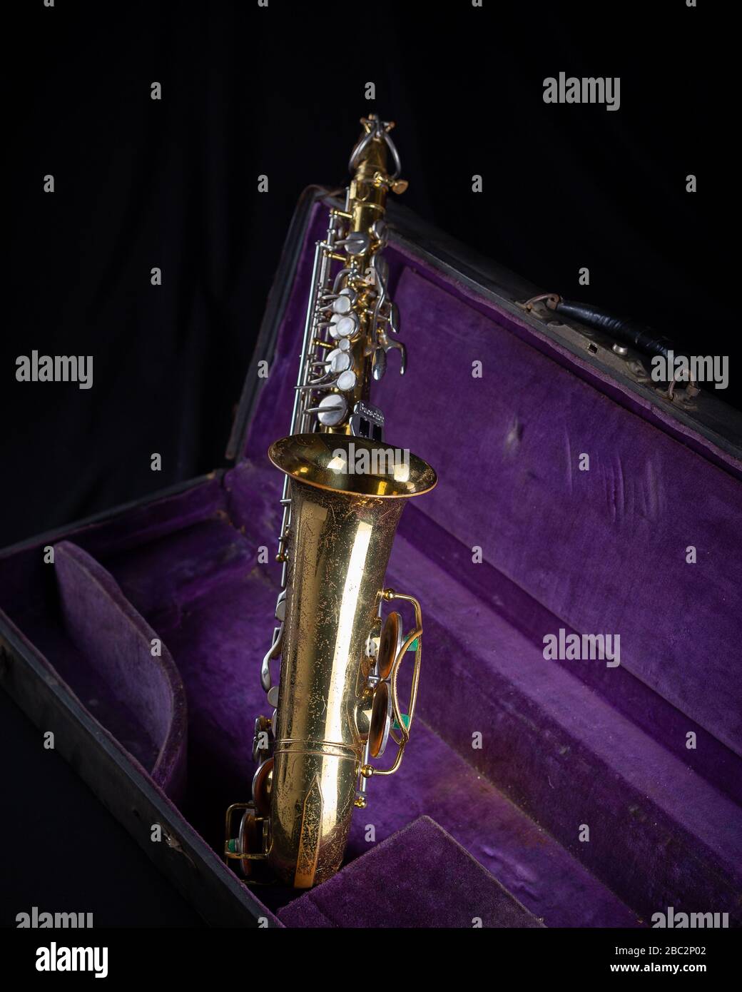 Buescher Alto Sax, Gold lackiert in Deep Purple Velvet-Lined Hartschalenfront auf schwarzem Hintergrund Stockfoto