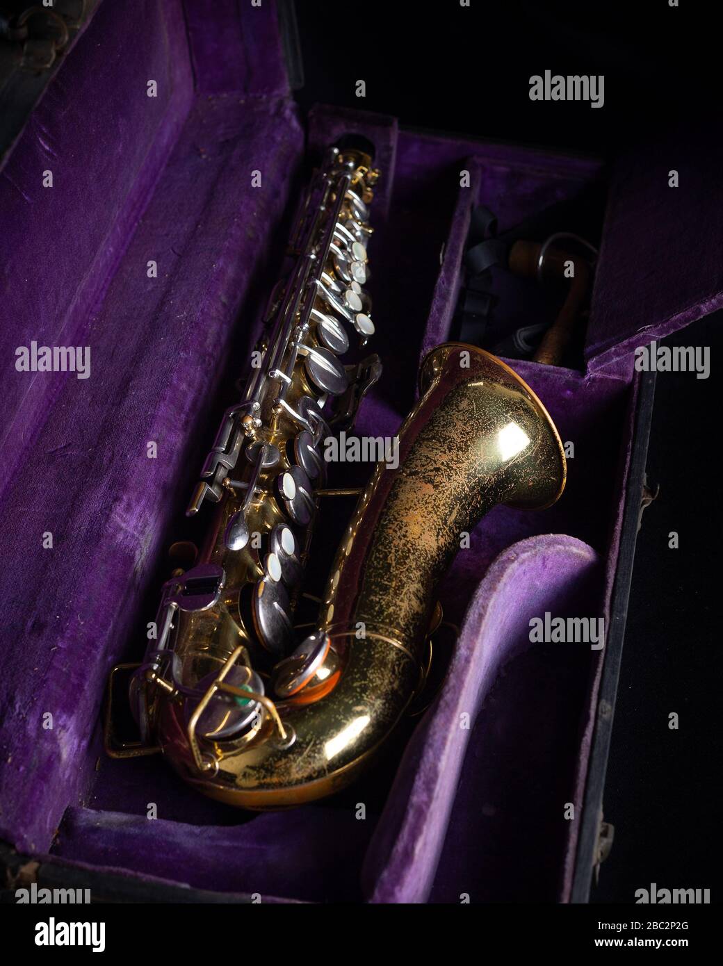 Buescher Alto Sax, Gold lackiert in tiefviolettem Velvet-Lined Hartschalenkoffer für den Fall auf schwarzem Hintergrund Stockfoto