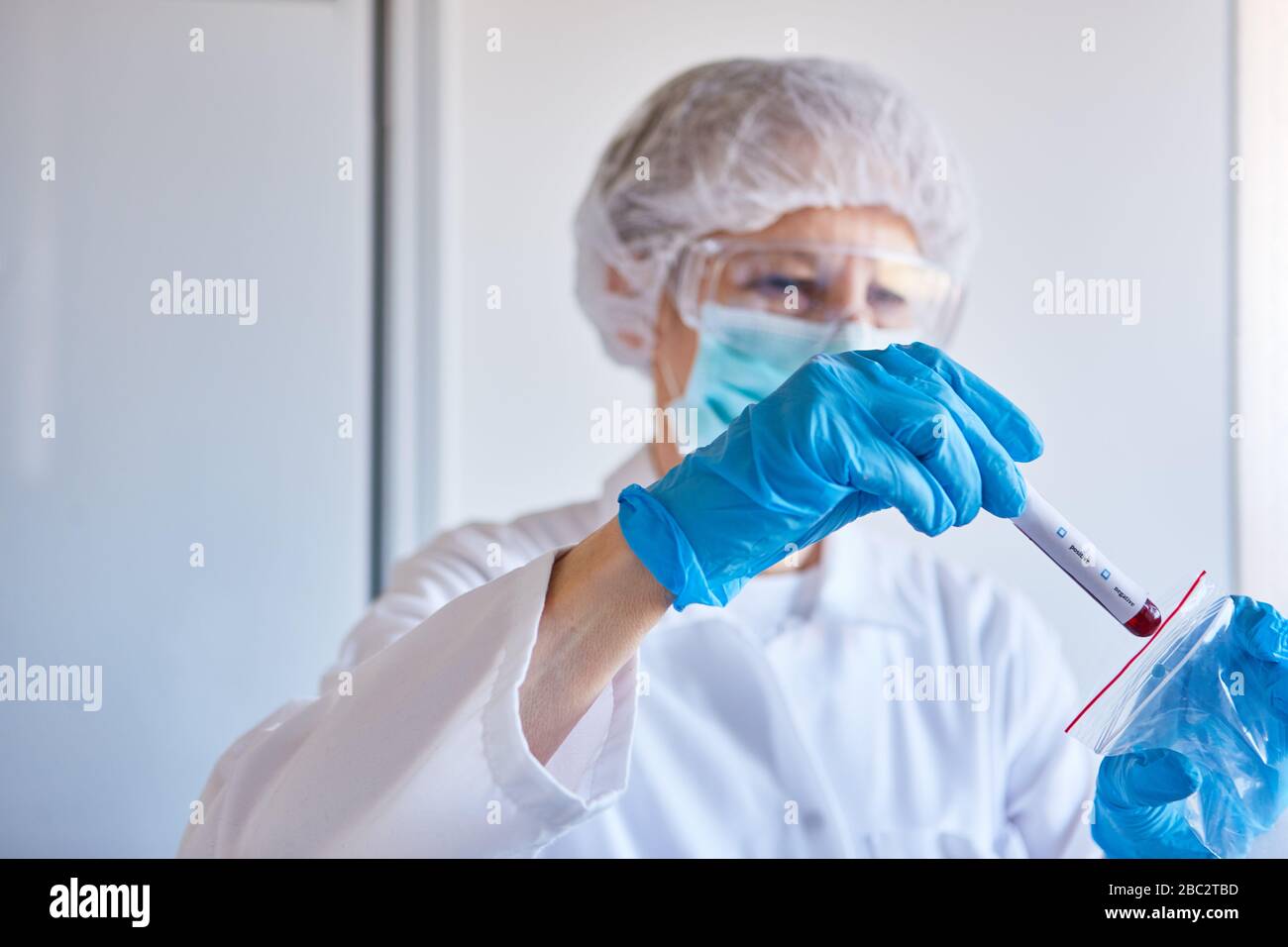 Laborforscher mit Blutprobe von Covid-19-Patienten arbeitet an einem Coronavirus-Impfstoff Stockfoto