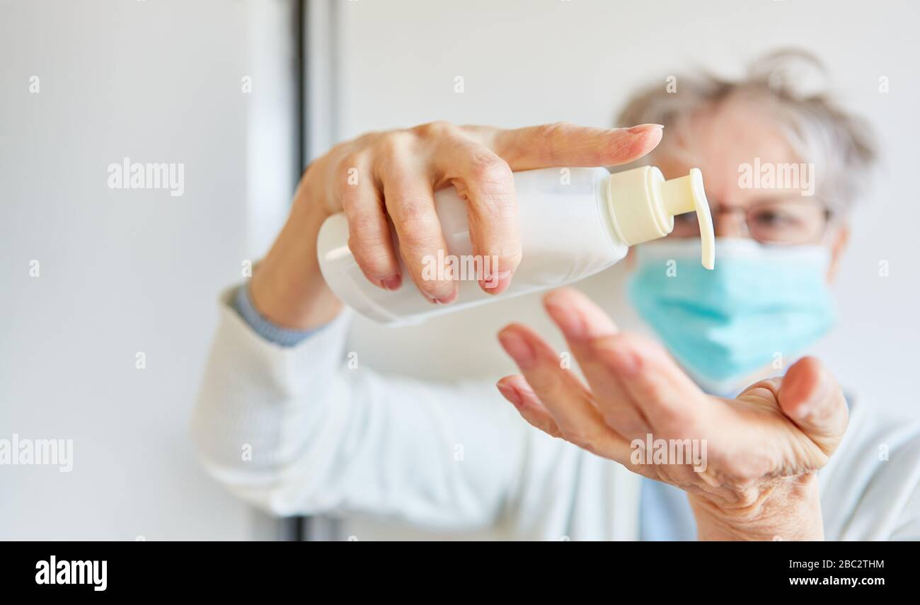 Weiblicher Arzt mit Mundschutz desinfizierenden Händen während der Covid-19-Coronavirus-Epidemie Stockfoto
