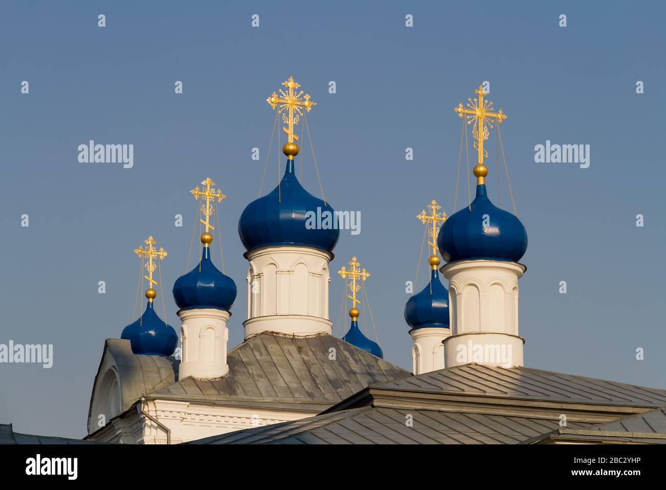 Goldene Kreuze und Kuppeln der russischen orthodoxen Kirche gegen den blauen Himmel. Stockfoto