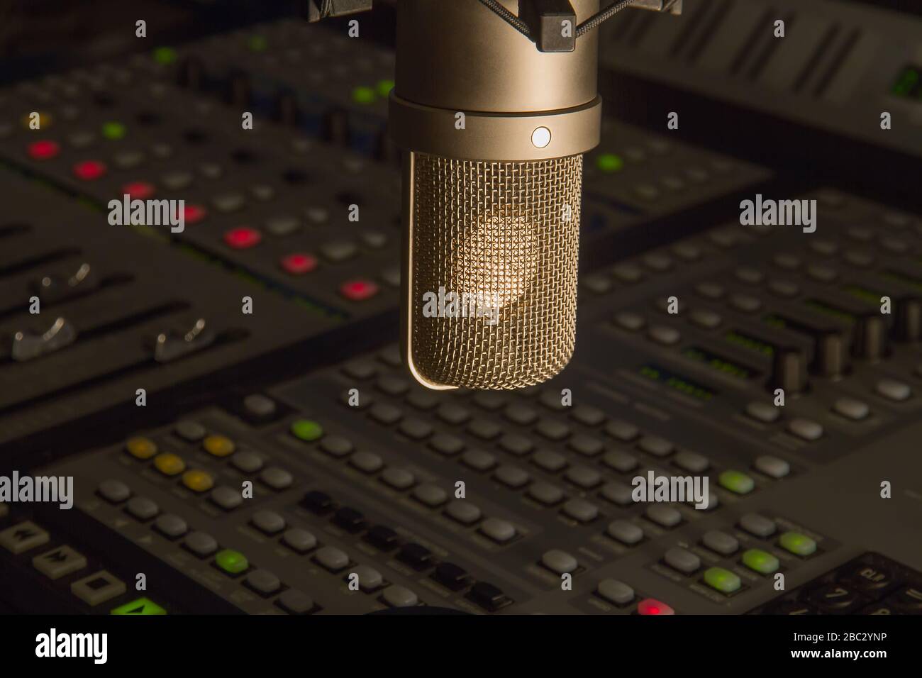 Professionelles Kondensatormikrofon über modernes digitales Audio-Mischpult im Produktionsstudio. Stockfoto