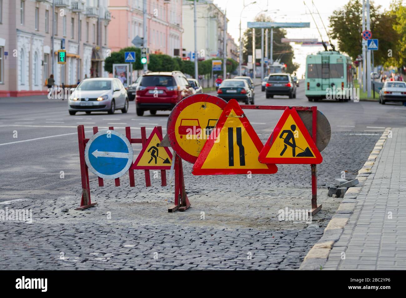 Warnschilder und Zäune im Bereich der Straße funktionieren auf einer belebten Straße. Stockfoto