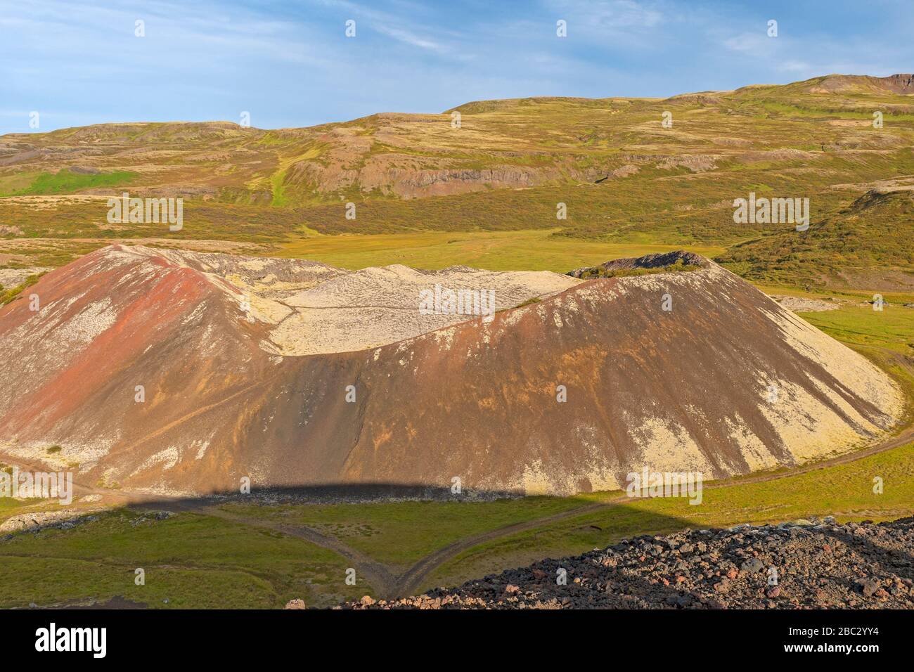 Grabrokarfell-Krater, der in einer Vulkanlandschaft in der Nähe von Grabrok, Island, aus den Schatten ragt Stockfoto