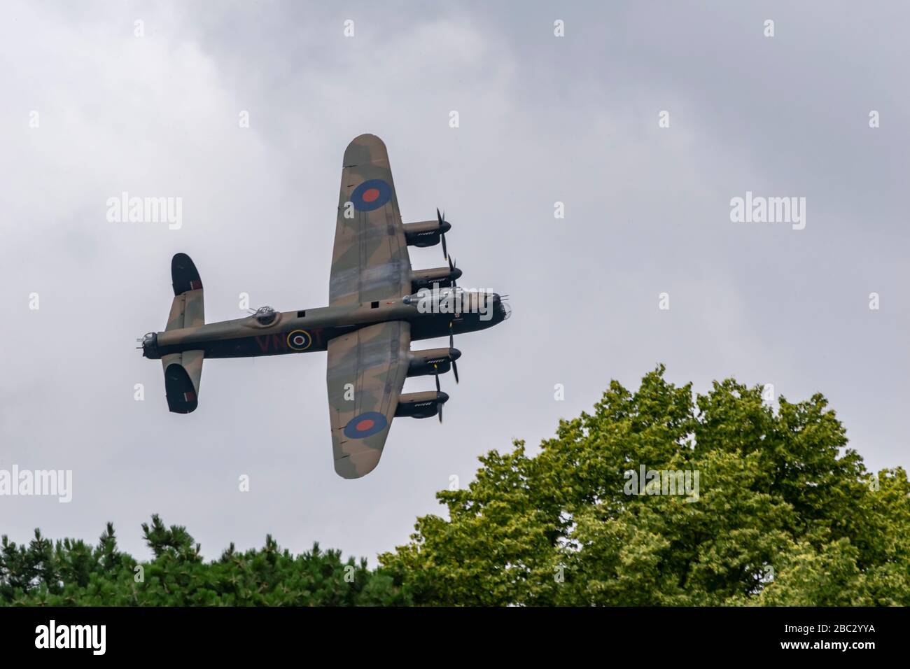 Lancaster Bomberflugzeug fliegt in Luftanzeige vorbei an Bäumen Stockfoto