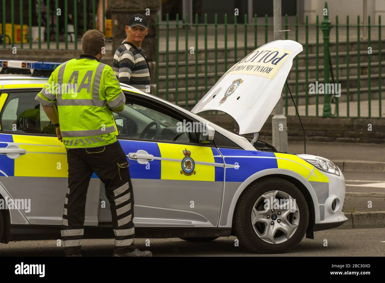 SWANSEA, WALES - JULI 2018: Mechaniker der AA besucht einen zerbrochenen Polizeipatrouillenwagen der RAF in Swansea, Wales. Stockfoto