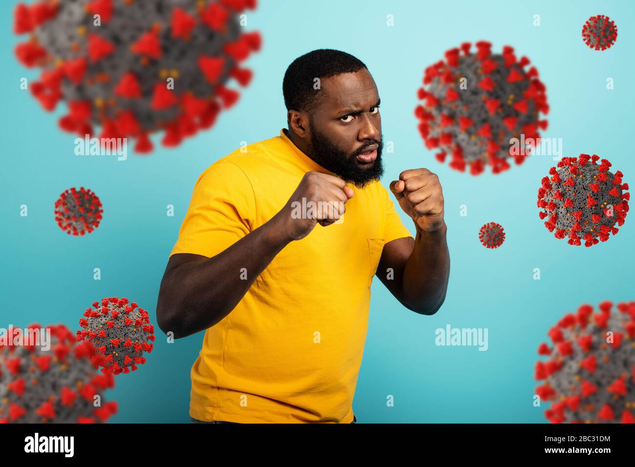 Der Mensch greift mit einem Schlag das Kovid19-Coronavirus an. Blauer Hintergrund Stockfoto