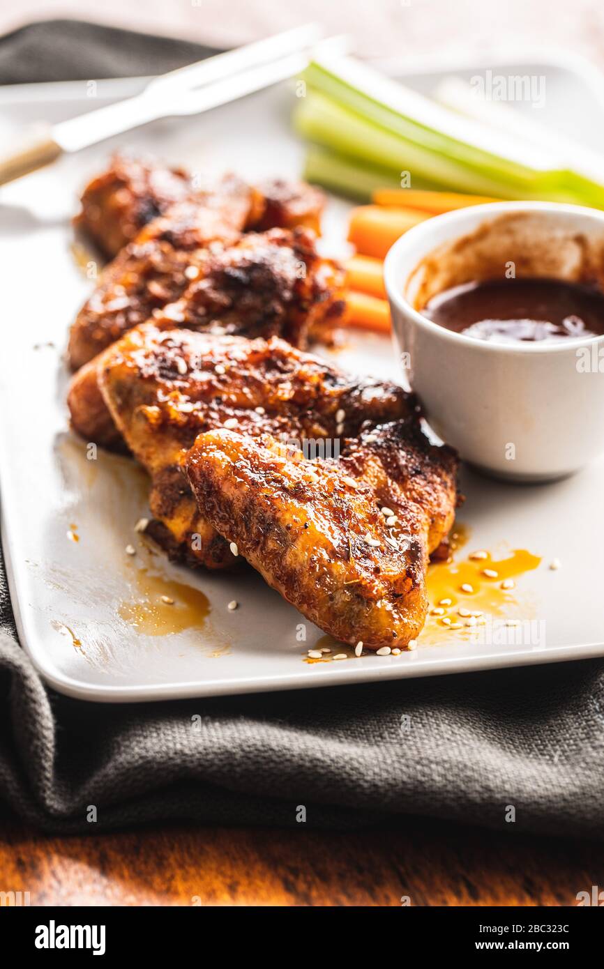 Gegrillte Hühnerflügel mit BBQ-Sauce auf dem Teller. Stockfoto