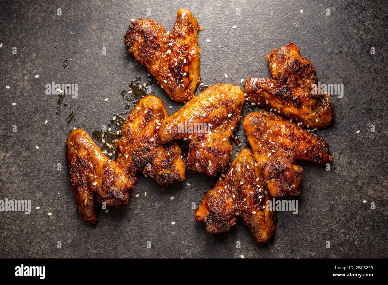 Gegrillte Hühnerflügel auf schwarzem rustikalen Tisch. Stockfoto