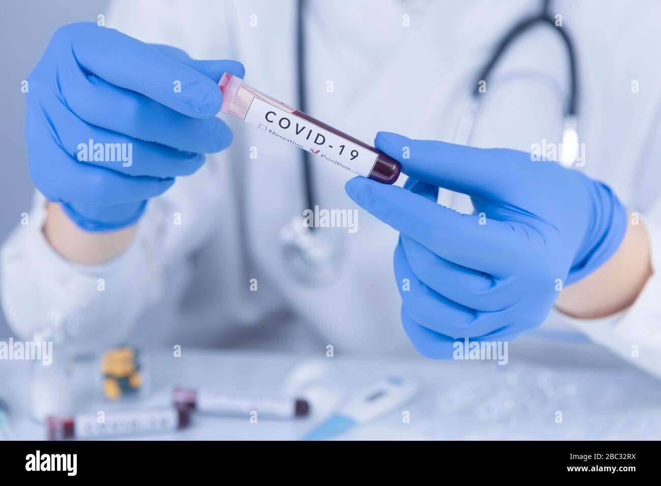 Arzt Hände mit Schutzhandschuhen, die COVID 19 Coronavirus Testblut analysieren. Virentest- und Forschungskonzept. Nahaufnahme Stockfoto