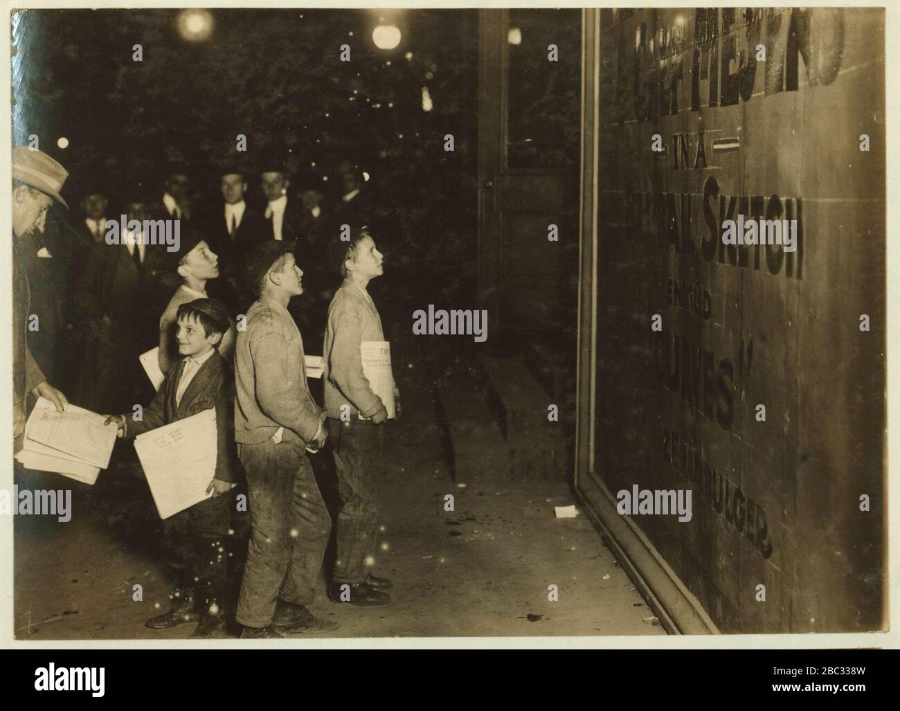 Eine Gruppe von Neugeborenen, die um den Long Acre Square hängen und warten, bis das Theater geschlossen wird. Foto aufgenommen in Victoria Theatra (d. H. Theater), B'(Road)Way und 42. St. James Thorpe (Junge verkaufen Stockfoto