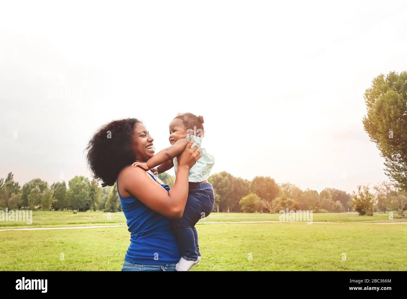Glückliche Mutter hat Spaß mit ihrer Tochter im Park im Freien - liebevolle Familie genießt gemeinsame Zeit - Eltern lieben und Mutter Tageskonzept Stockfoto