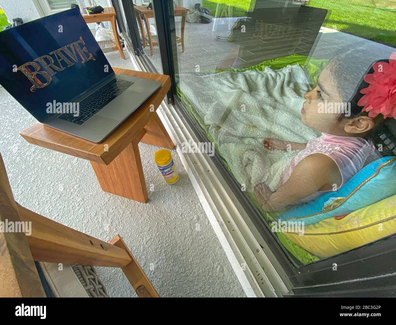 Filmzeit durch ein Glasfenster. Normalisierung des Kinderlebens während der COVID-19-Quarantäne. Stockfoto