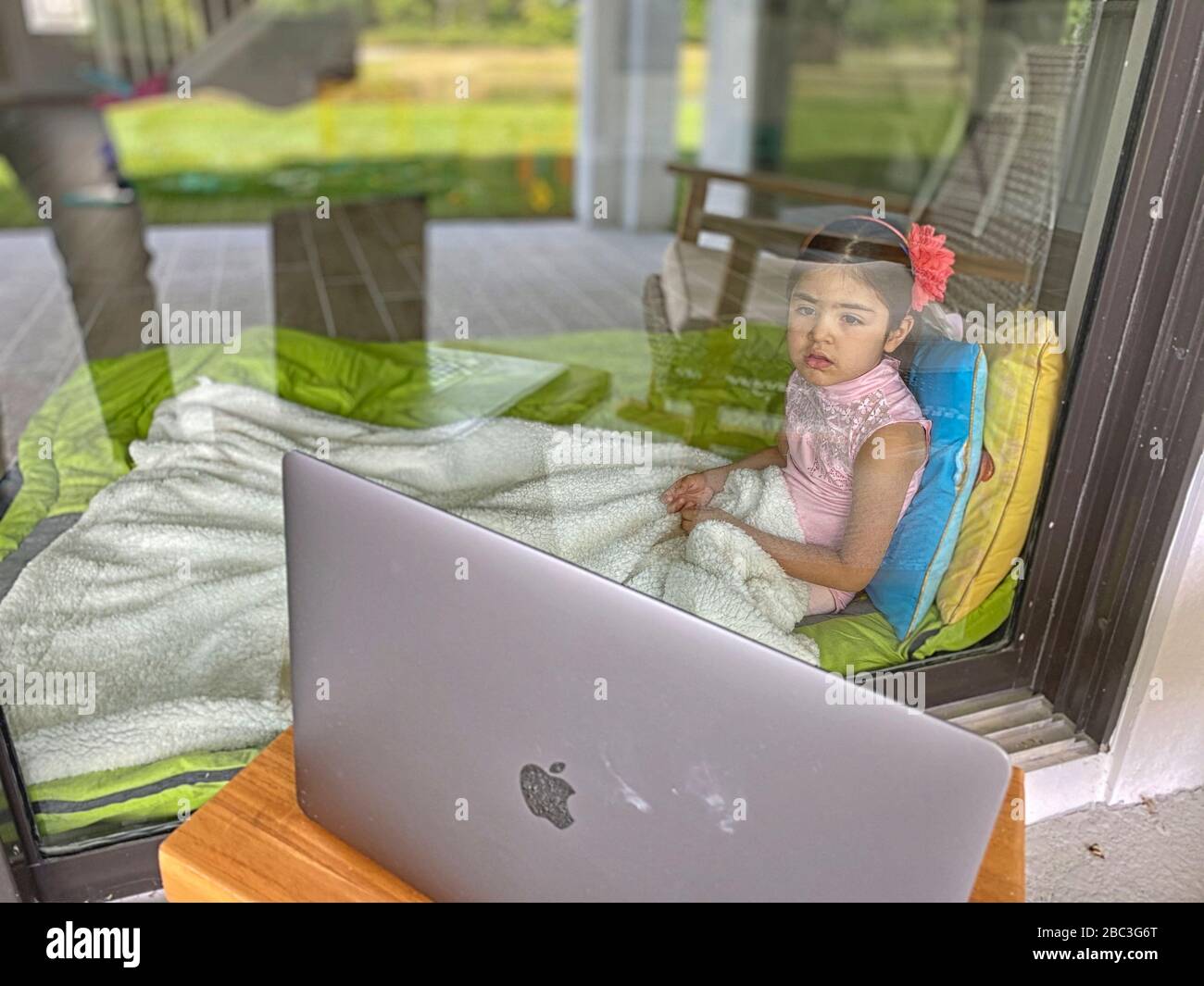 Filmzeit durch ein Glasfenster. Normalisierung des Kinderlebens während der COVID-19-Quarantäne. Stockfoto