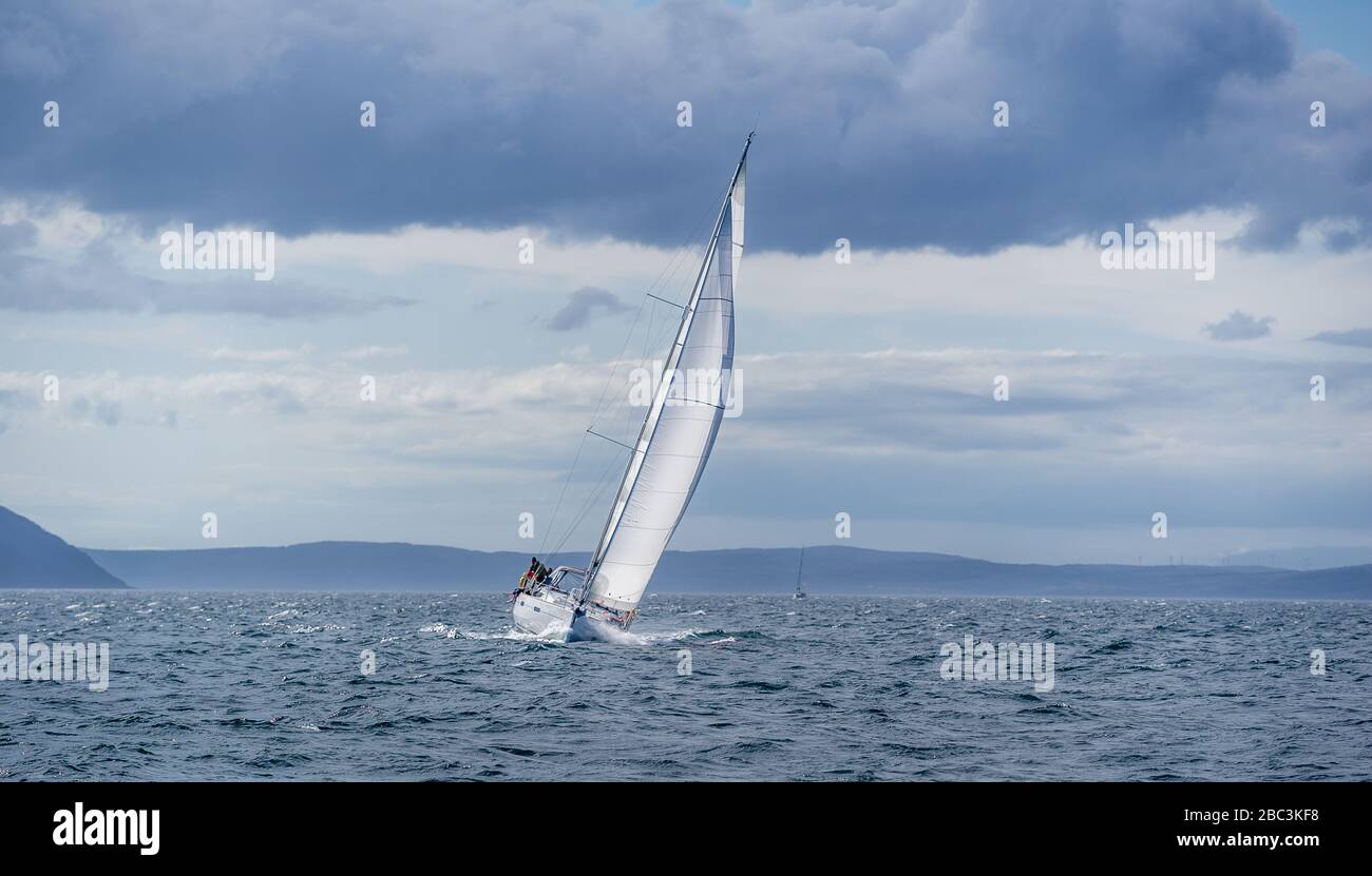Segelboot im Regattamodus, volle Geschwindigkeit und guter Hechelwinkel. In der Nähe von Arran Island, Schottland Stockfoto
