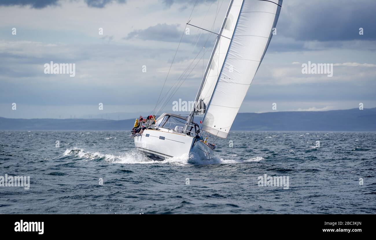 Neue Segelyacht geht schnell und schön direkt auf die Kamera. Segelregatta in den Gewässern Schottlands. Stockfoto