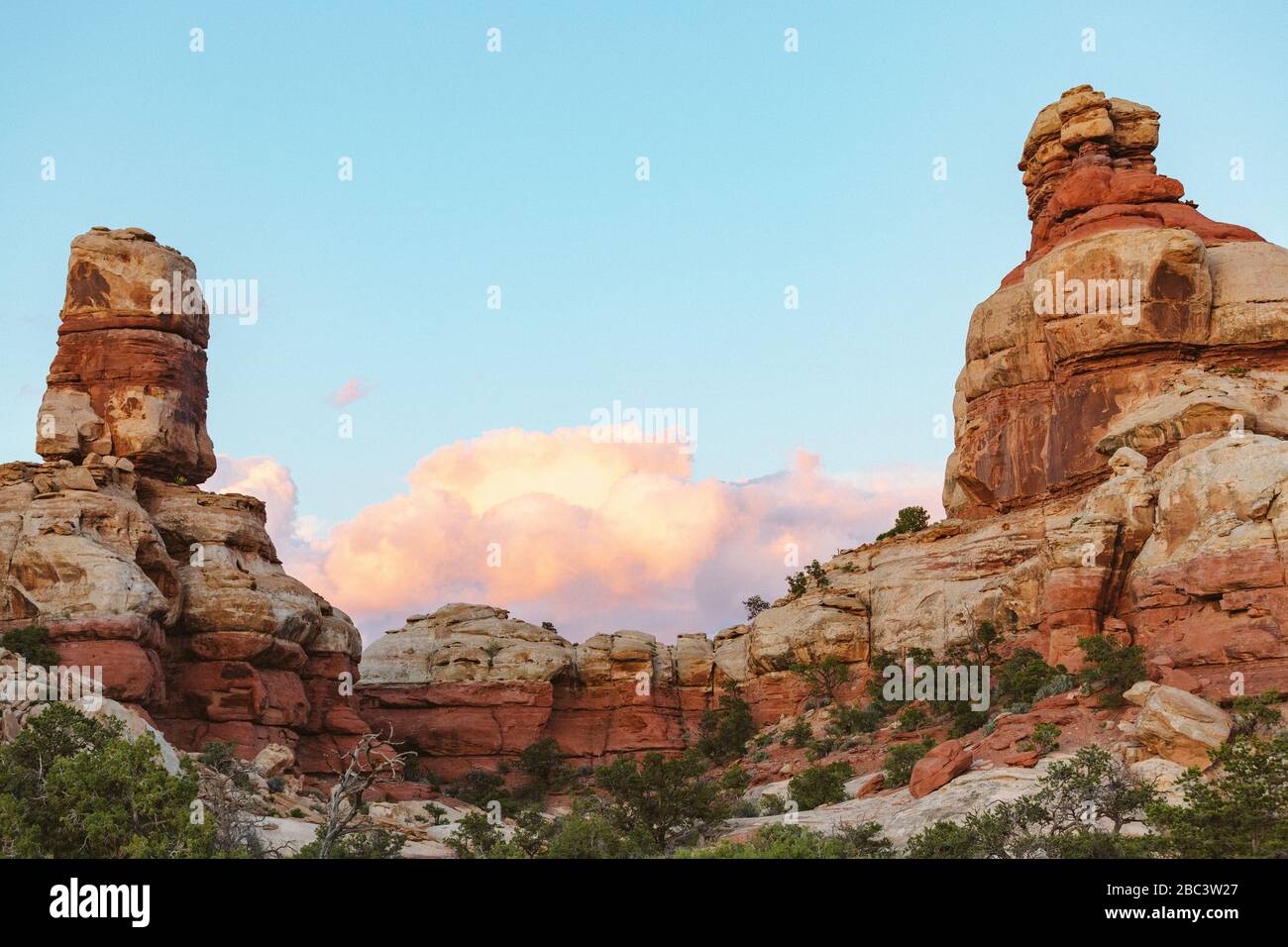 Blauer Himmel und rosa Wolken über roten Sandsteintürmen in canyonlands Stockfoto
