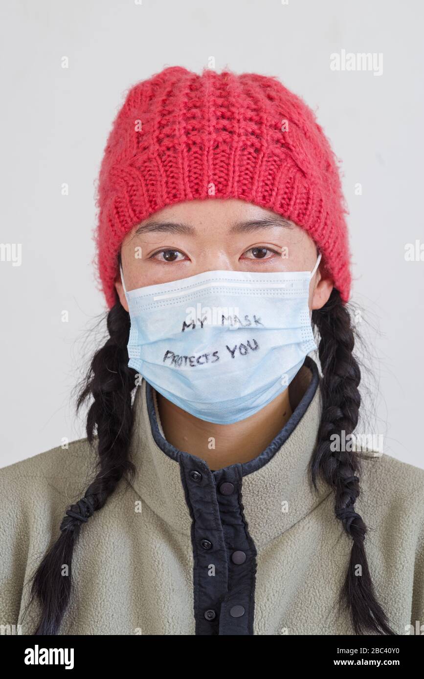Der Kopfschuss einer asiatischen Frau mit meiner Maske schützt Sie in einer Markierung auf ihrer Gesichtsmaske Stockfoto