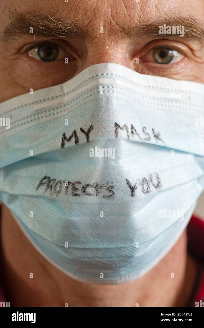 Mann mittleren Alters mit Gesichtsmaske, die besagt, dass meine Maske Sie in einem schwarzen Stift darauf schützt Stockfoto
