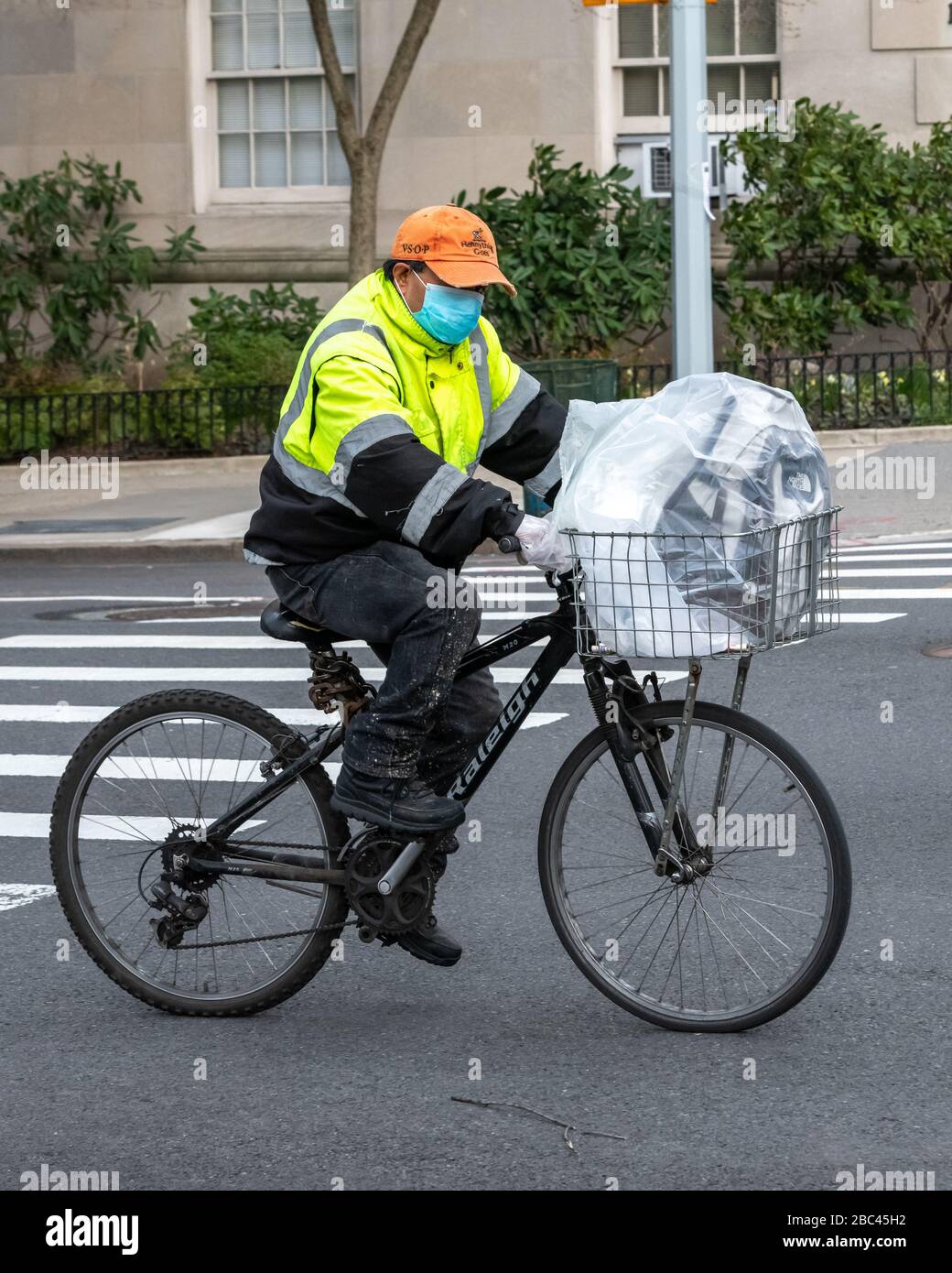 New York, USA. April 2020. Ein Liefermann trägt eine Gesichtsmaske, als er mit seinem Fahrrad in New York City fährt. Heute sagte die Regierung, dass Newyorkers ihre Gesichter bedecken sollten, wenn sie nach draußen gehen, um eine Ausbreitung des Coronavirus zu verhindern. Kredit: Enrique Shore/Alamy Live News Stockfoto