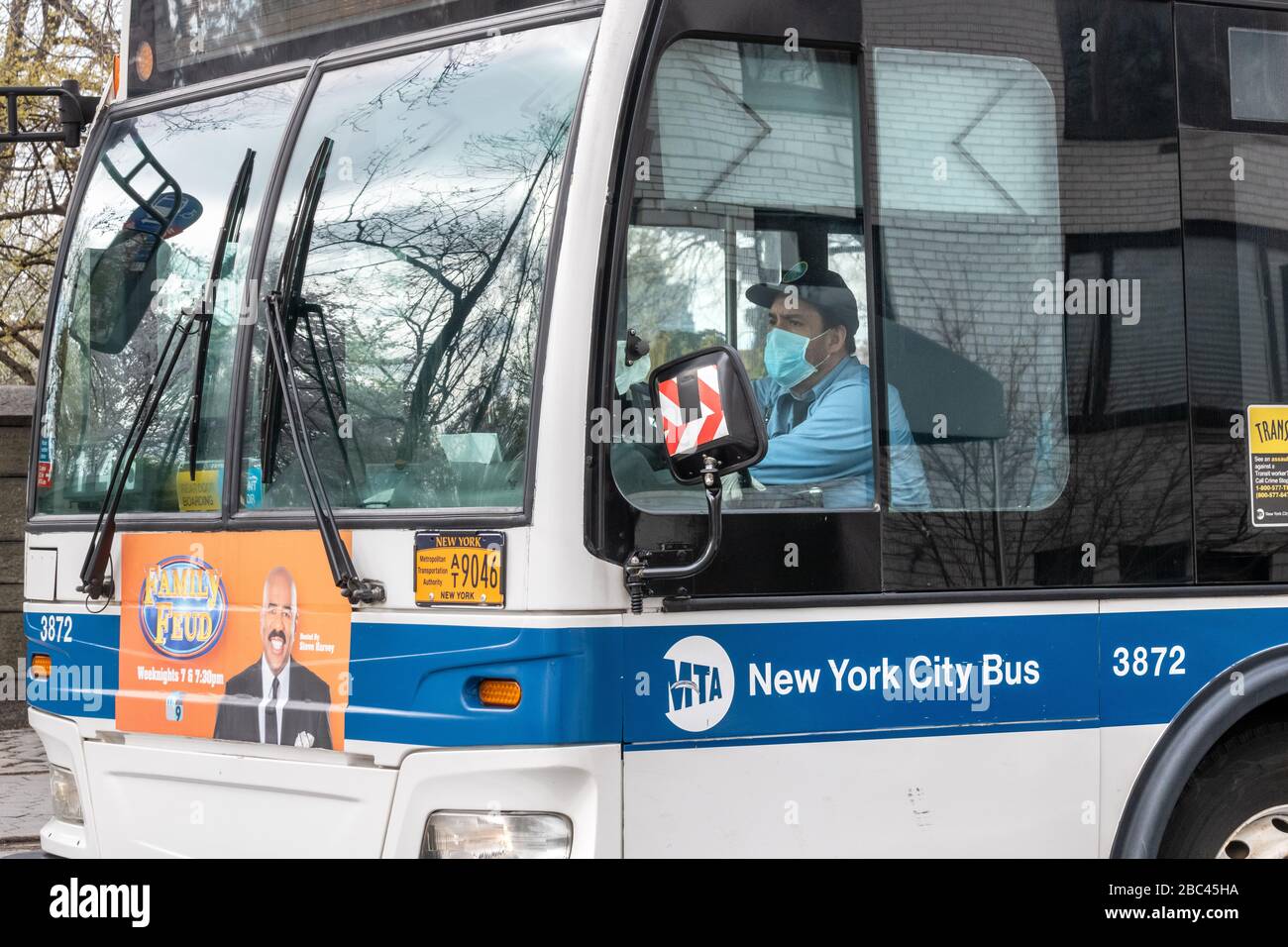 New York, USA. April 2020. Ein öffentlicher Busfahrer trägt während der Fahrt in New York City eine Gesichtsmaske. Heute sagte die Regierung, dass Newyorkers ihre Gesichter bedecken sollten, wenn sie nach draußen gehen, um eine Ausbreitung des Coronavirus zu verhindern. Kredit: Enrique Shore/Alamy Live News Stockfoto