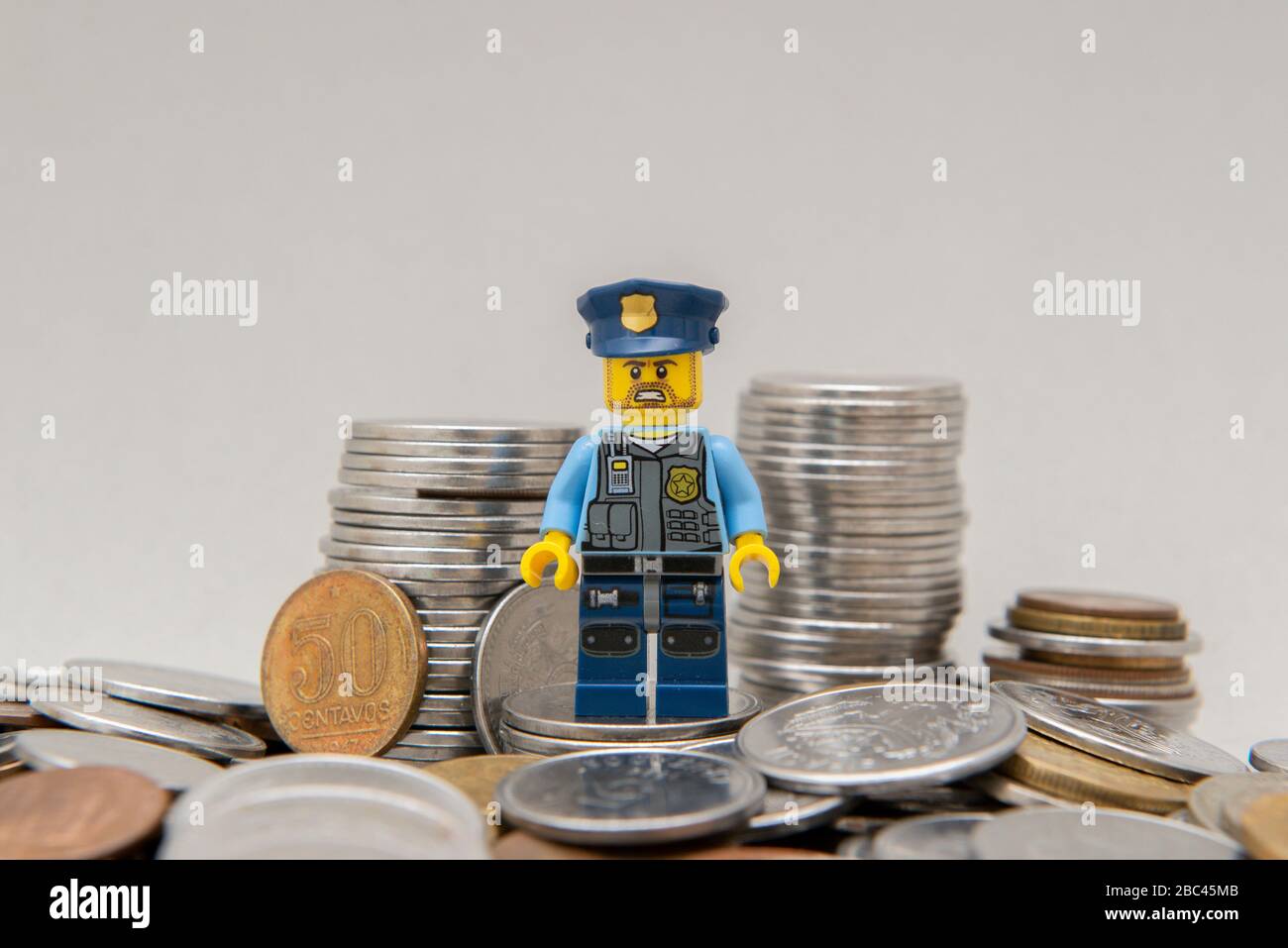 Florianopolis, Brasilien, 28. März 2020: Minifigure des Polizisten auf einem Geldhaufen. Der wahre Held verdiente größere Anerkennung für seine Tapferkeit. LEGO mi Stockfoto