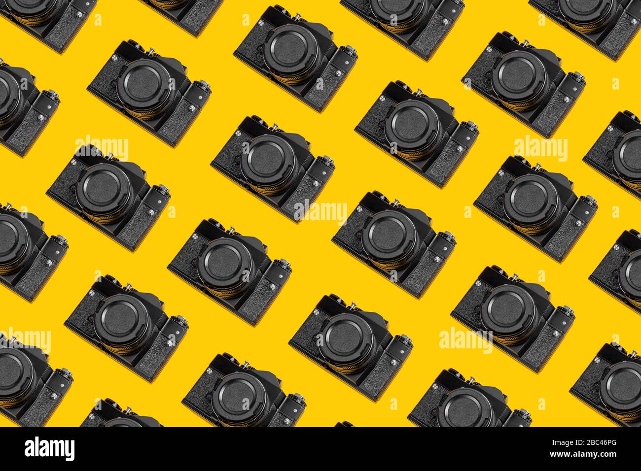 Modisches Muster von Retro-Kameras auf gelbem Hintergrund. Horizontaler Hintergrund. Foto-Konzept. Stockfoto