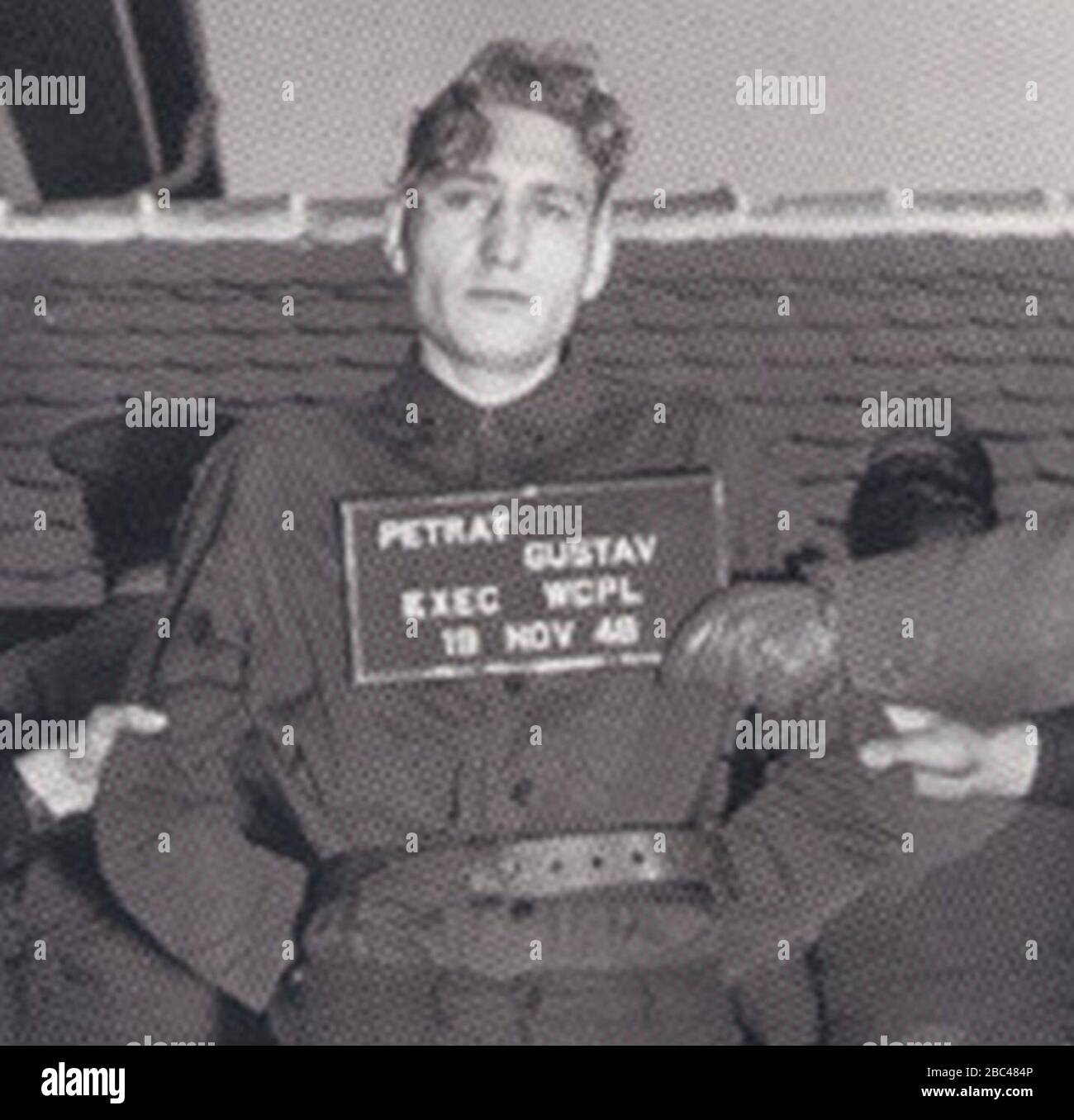 Gustav Petrat vor der Hinrichtung durch hängen mit dem Schild "PETRAT GUSTAV EXEC WCPL 19 Nov 48" (beschnitten). Stockfoto