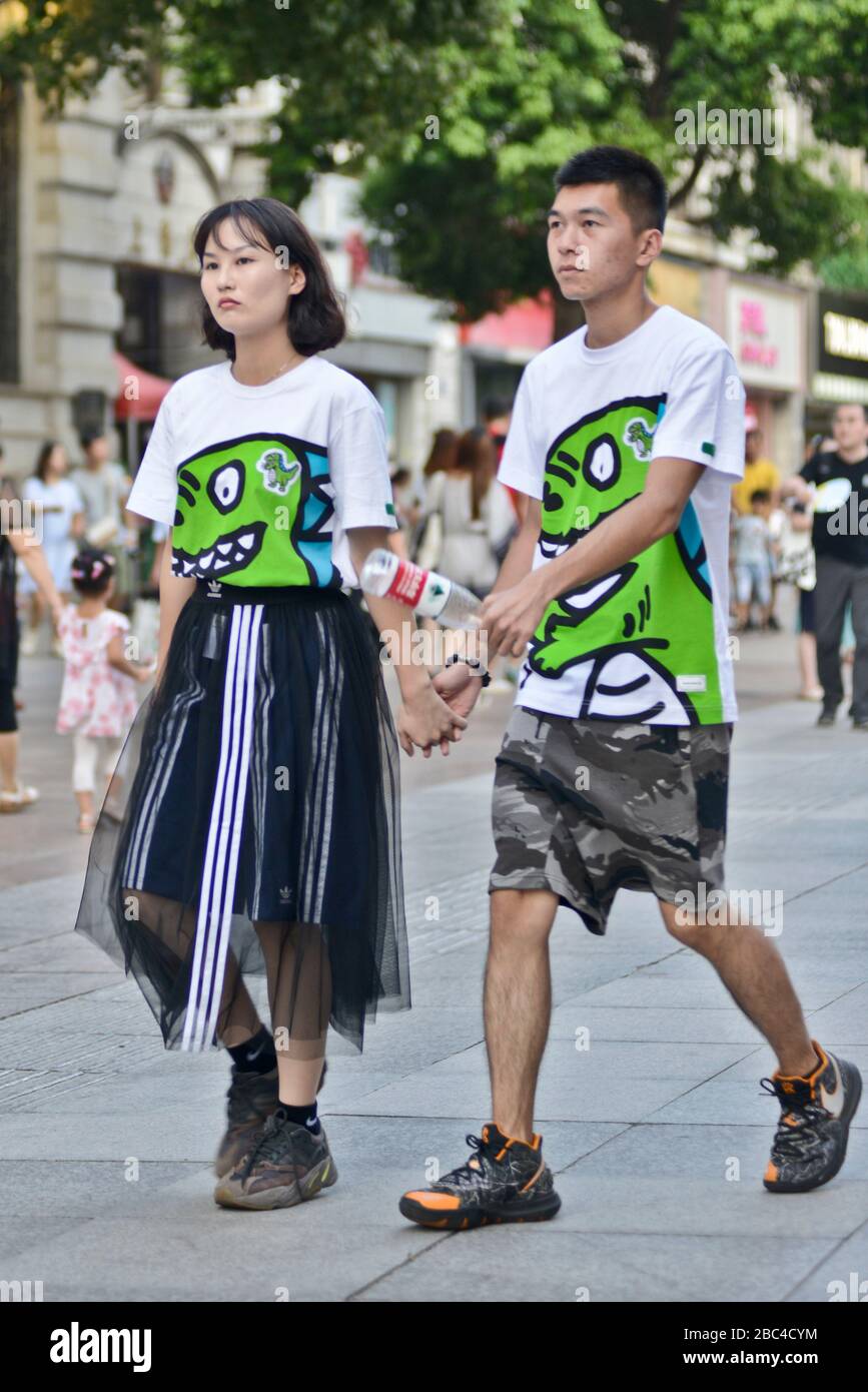 Ein chinesisches Paar trägt passende T-Shirts mit Drachendesign. Jianghan Road, Wuhan, China Stockfoto