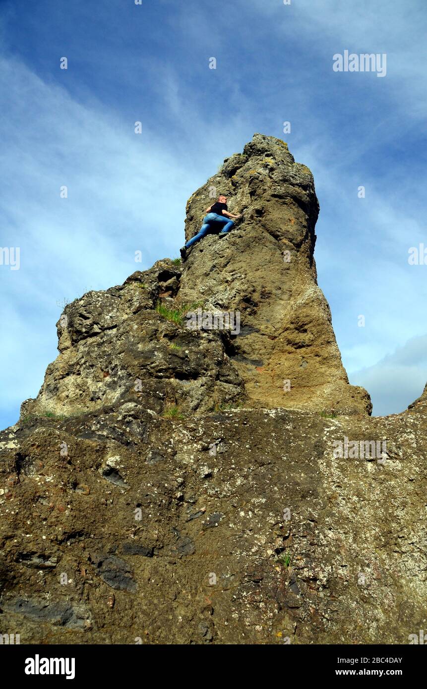 Ein junger Mann/Teenager befreit sich von einem Felsvorsprung Stockfoto