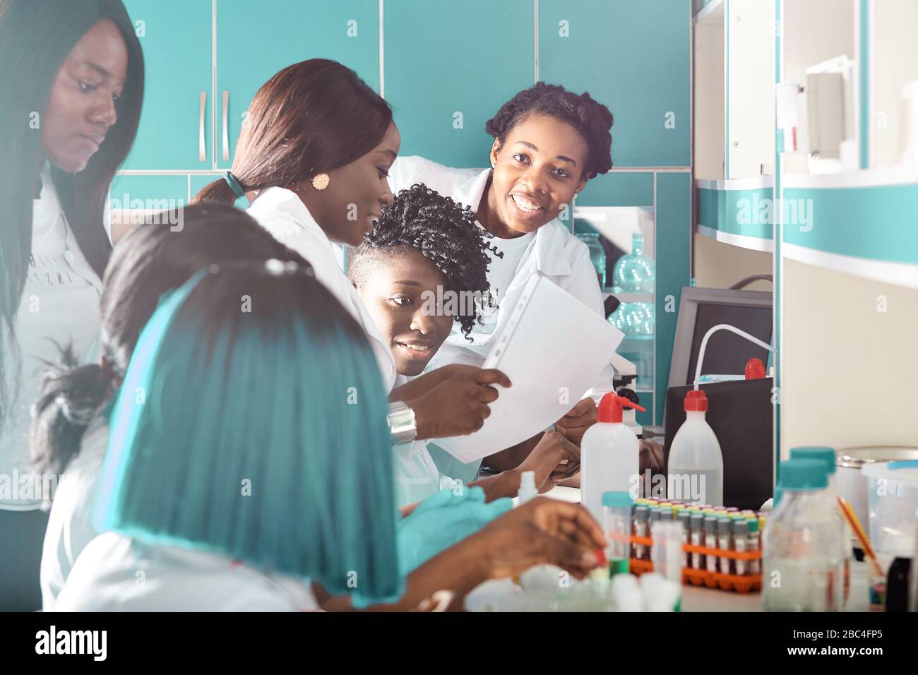 Weibliche afrikanische Medizinstudenten, junge Absolventen oder Ärzte diskutieren über die weitere Entwicklung des Impfstoffs Covid-19. Energisch ausdrucksstarke fröhliche Gruppe discussi Stockfoto