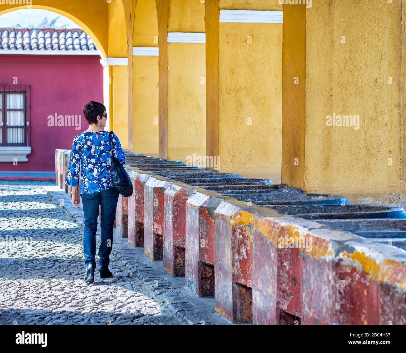 Eine Frau läuft auf der alten Cisterna de la Union in Antigua, Guatemala. Stockfoto