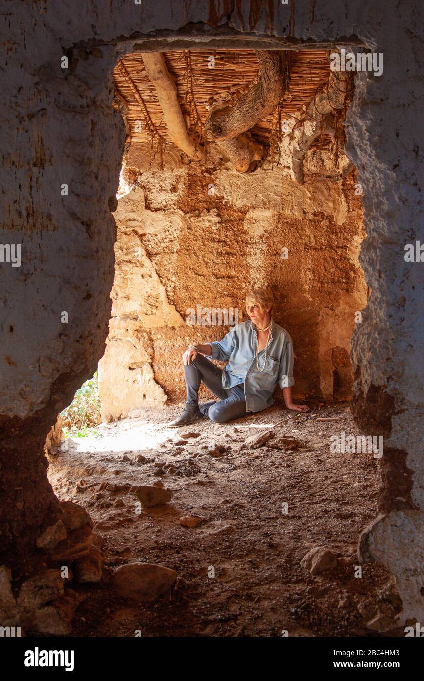 Attraktive Frau, die in ihrer verderbten spanischen Scheune posiert Stockfoto