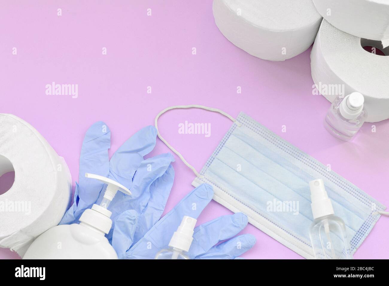 Satz wichtiger Elemente für Covid-19-Quarantänezeiten. Toilettenpapier, Einweghandschuhe aus Gummi mit chirurgischer Gesichtsmaske und Händededesinfektionsmittel mit Flüssigkeit so Stockfoto