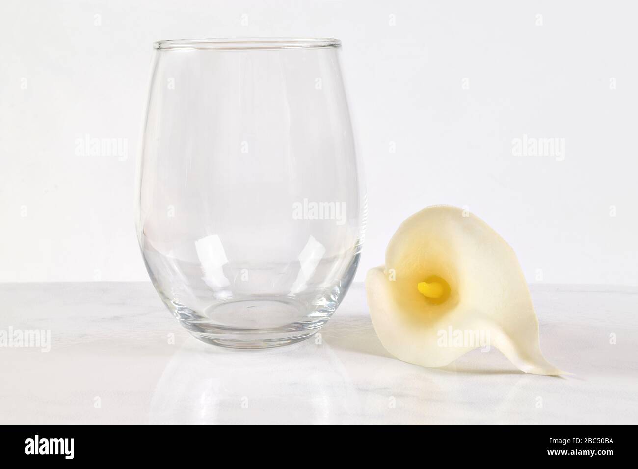 Dieser von Ostern inspirierte Mock up verfügt über einen stemmlosen Winzpass neben einer hübschen weißen Calla-Lilie. Stockfoto