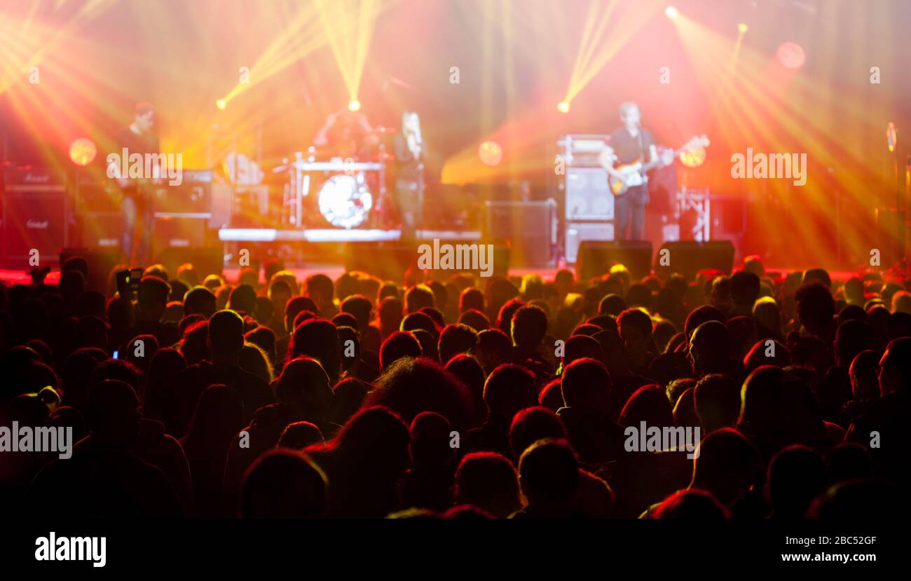 Bühne leuchtet auf Konzert. Beleuchtungseinrichtungen mit mehrfarbigen Balken. Silhouetten von Menschen und Musikern in großer Konzertbühne. Stockfoto