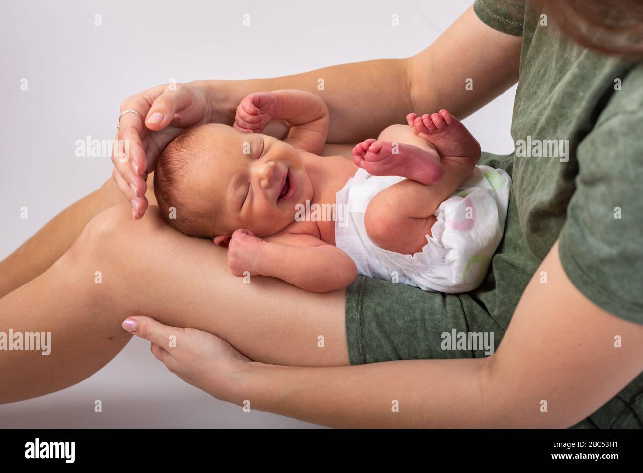 Schönes neugeborenes Baby, das auf den Händen der Mutter ruht Stockfoto