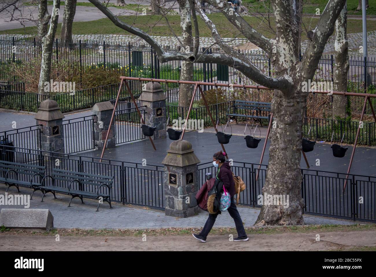 (200403) -- NEW YORK, 3. April 2020 (Xinhua) -- EINE Frau, die eine Gesichtsmaske trägt, läuft am geschlossenen Spielplatz im Fort Greene Park im New Yorker Stadtteil Brooklyn, den Vereinigten Staaten, 2. April 2020 vorbei. Spielplätze in New York City waren geschlossen, um den Ungehorsam der Aufrechterhaltung sozialer Distanzierung anzugehen. (Foto von Michael Nagle/Xinhua) Stockfoto