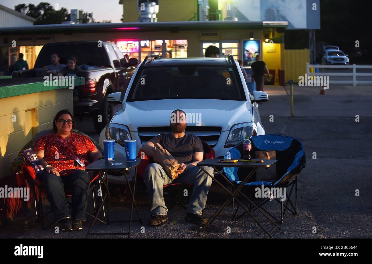April 2020 - Lakeland, Florida, Vereinigte Staaten - Menschen bereiten sich darauf vor, einen Film von Stühlen zu genießen, die mit ihrem Auto im Silver Moon Drive-in-Theater in Lakeland, Florida am 2. April 2020 eingerichtet wurden. Die letzte Nacht der Operation vor dem landesweiten Befehl zum Aufenthalt zu Hause, der von Florida-Gouverneur Ron DeSantis herausgegeben wurde, um die Ausbreitung von Coronavirus einzudämmen, tritt in Kraft. Der Silbermond mit zwei Bildschirmen, der letzte noch in Polk County, Florida, befindliche Eintrieb, hat eine Steigerung des Geschäftsbetriebs erlebt, seit die Pandemie COVID-19 die Schließung von Innentheatern erzwang. (Paul Hennessy/Alamy) Stockfoto
