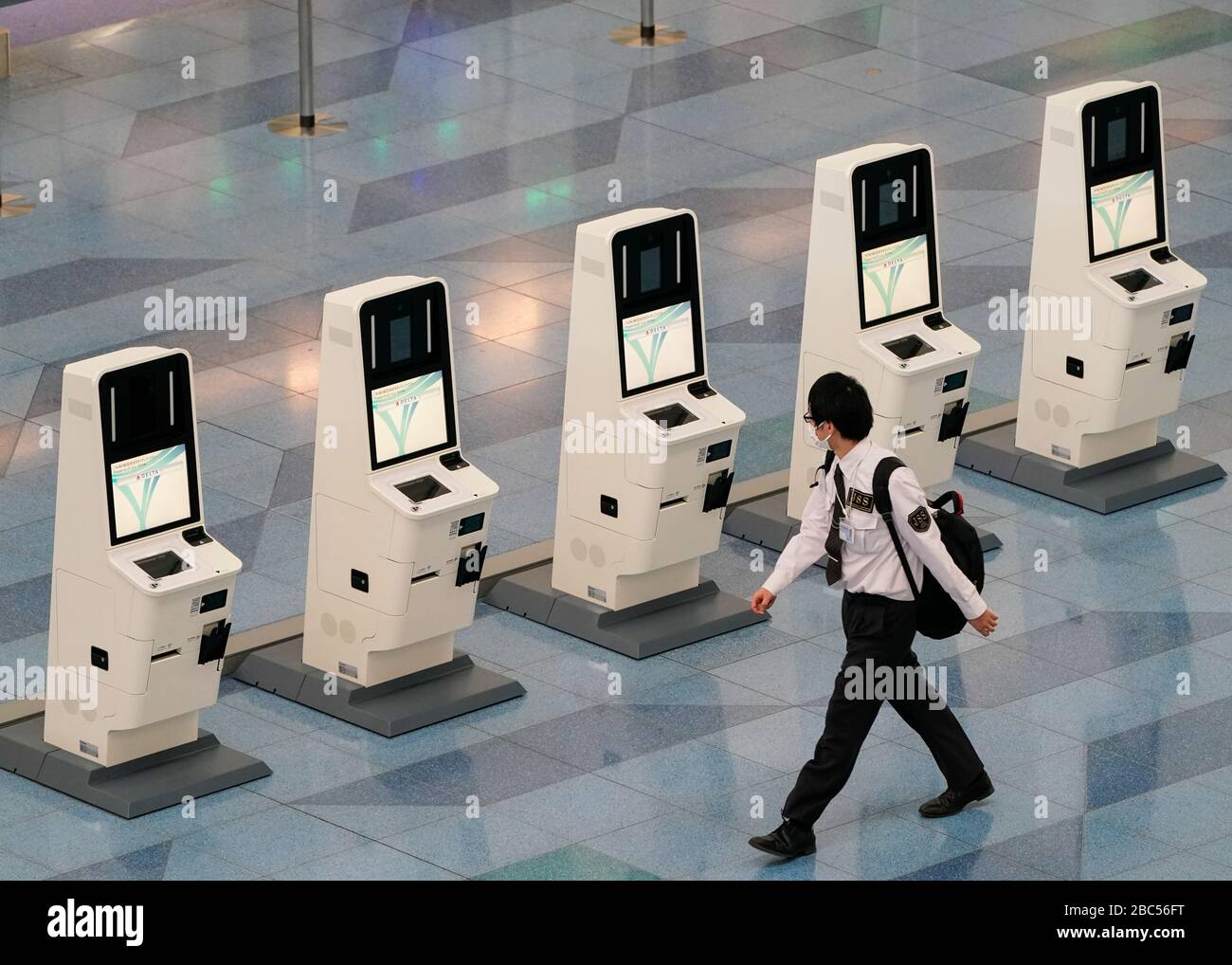 Tokio, Japan. April 2020. Ein Sicherheitspersonal läuft am internationalen Flughafen Tokio an unbesetzten Flugscheckmaschinen vorbei. Das neue japanische Einreiseverbot, das heute verhängt wird, wird sich auf ausländische Staatsangehörige aus 73 Ländern und Regionen ausdehnen, zu denen die Vereinigten Staaten, Kanada, Großbritannien und der Großteil Europas und Chinas gehören, um die Verbreitung von COVID-19 in Japan zu bekämpfen. Credit: AFLO/Alamy Live News Stockfoto