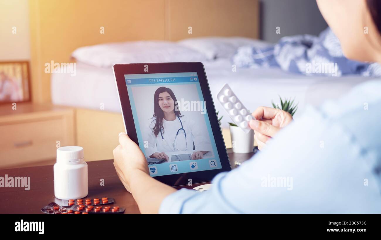 Kranke Frau nutzt Videokonferenz, macht Online-Rücksprache mit dem Arzt auf der digitalen Tablette, Patient fragt den Arzt über Krankheit und Medikamente per Video cal Stockfoto