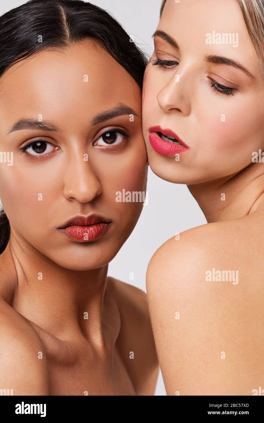 Nahaufnahme des Porträts wunderschöner afrikanischer und kaukasischer Mädchen mit perfekter Haut. Stockfoto
